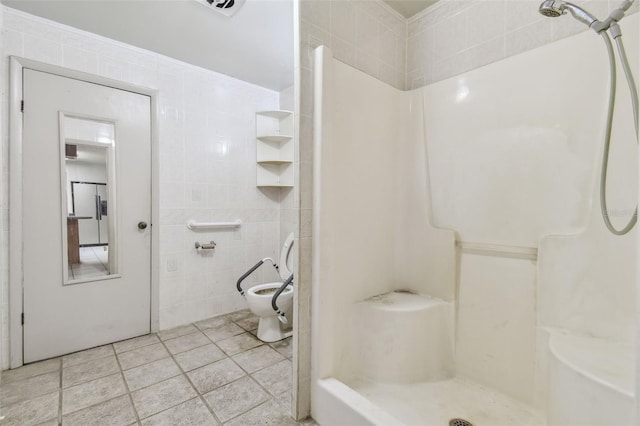 bathroom with tile walls, tile patterned flooring, walk in shower, toilet, and crown molding