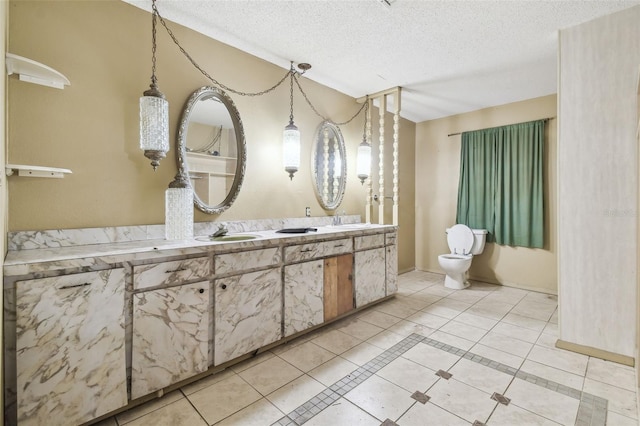 bathroom with vanity, tile patterned floors, toilet, and a textured ceiling