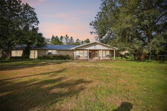 ranch-style house with a porch and a yard