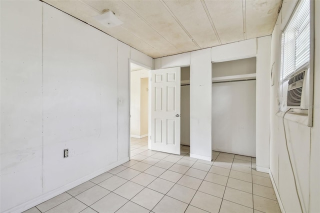 unfurnished bedroom featuring light tile patterned floors and cooling unit