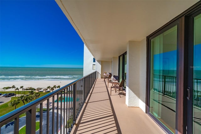 balcony with a water view and a beach view