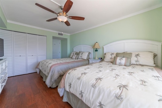 bedroom featuring dark wood-type flooring, ornamental molding, a closet, and ceiling fan