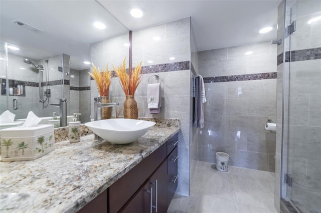 bathroom with vanity, tile walls, and walk in shower