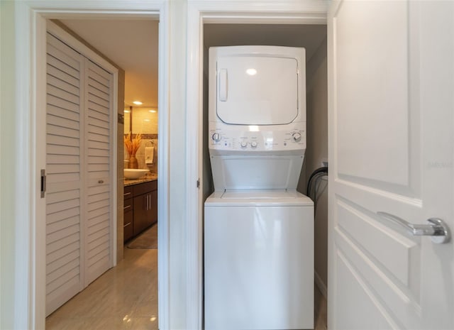 washroom with light hardwood / wood-style floors and stacked washer / dryer