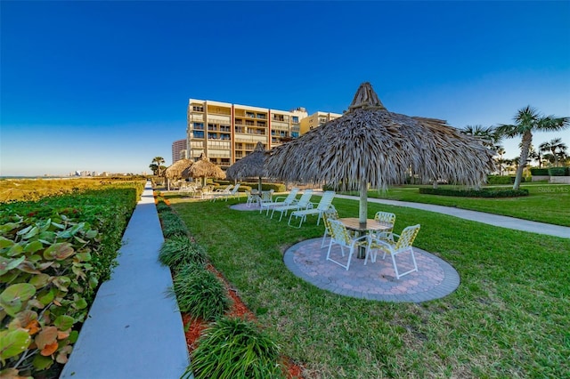 view of home's community featuring a patio area and a lawn