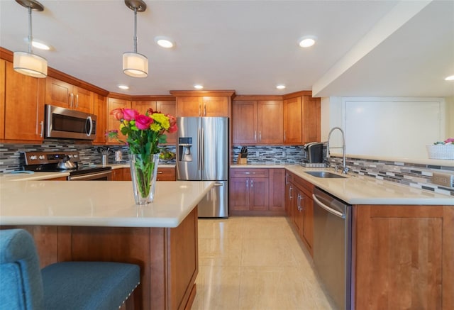 kitchen featuring a kitchen bar, sink, decorative light fixtures, appliances with stainless steel finishes, and backsplash