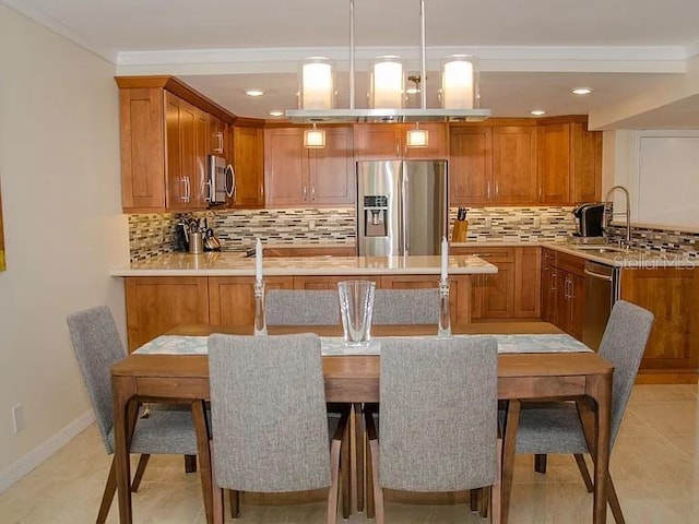 kitchen with appliances with stainless steel finishes, decorative light fixtures, sink, and backsplash