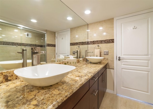 bathroom featuring vanity, tile walls, and an enclosed shower