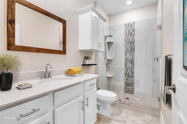 bathroom featuring vanity, an enclosed shower, and toilet