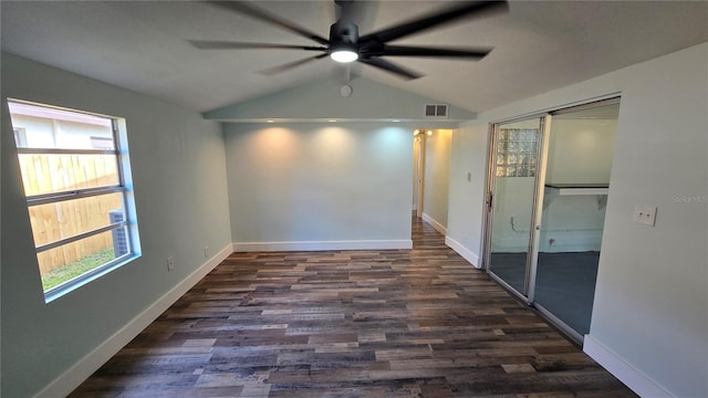 empty room with dark hardwood / wood-style flooring, vaulted ceiling, and ceiling fan