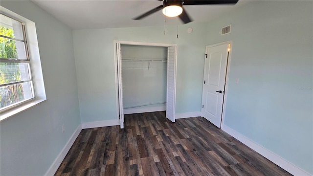 unfurnished bedroom with dark hardwood / wood-style flooring, a closet, and ceiling fan