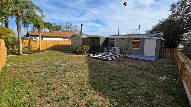 rear view of house with ac unit, a sunroom, a patio area, and a lawn