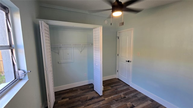 unfurnished bedroom with dark wood-type flooring, ceiling fan, and a closet