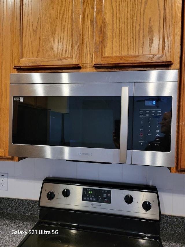 interior details with dark stone countertops and appliances with stainless steel finishes