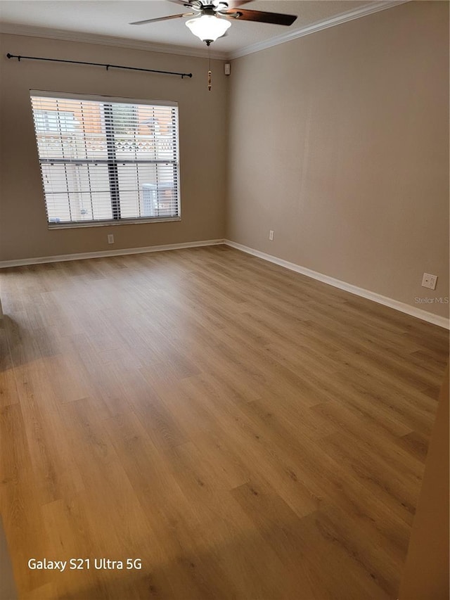 spare room featuring ceiling fan, ornamental molding, and light wood-type flooring