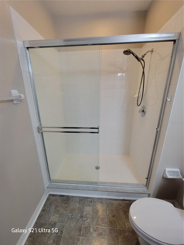 bathroom featuring toilet and an enclosed shower