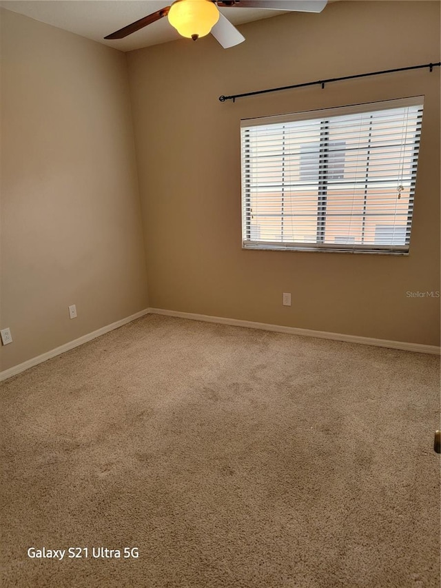 unfurnished room featuring ceiling fan and carpet