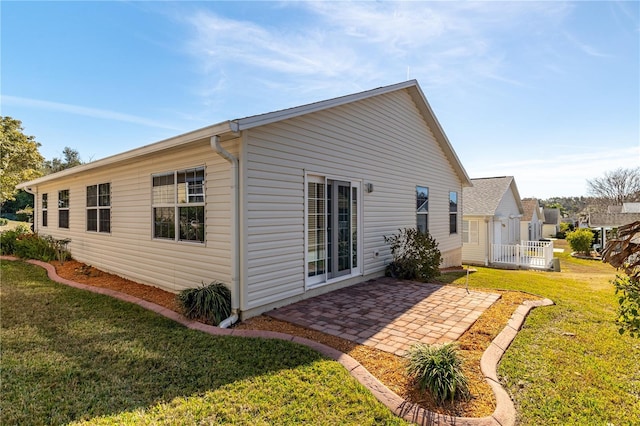 rear view of property with a yard and a patio area