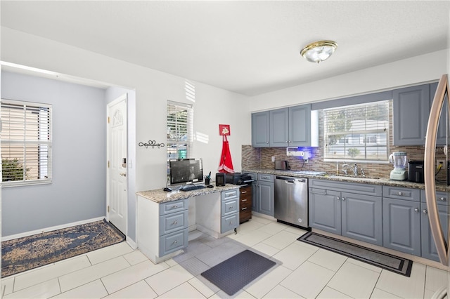 kitchen with sink, backsplash, gray cabinets, and stainless steel dishwasher