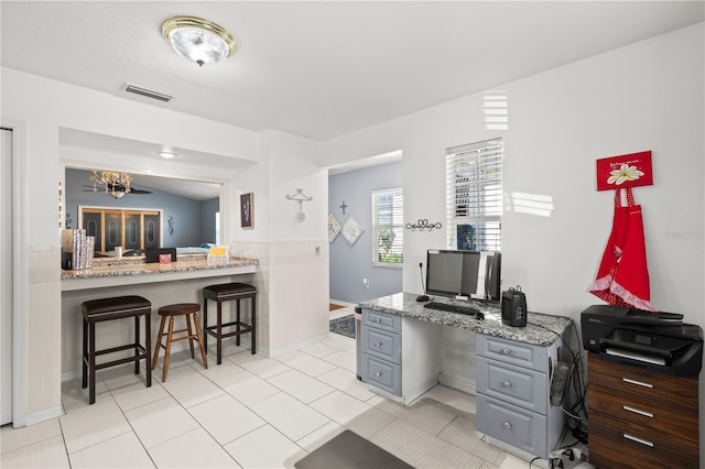 office space with built in desk and light tile patterned floors