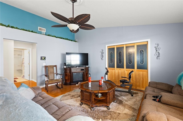 living room featuring light hardwood / wood-style flooring, vaulted ceiling, and ceiling fan