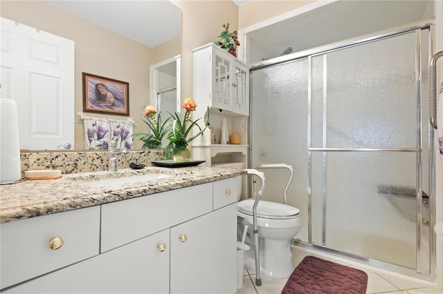 bathroom with tile patterned flooring, vanity, a shower with door, and toilet