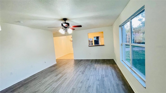 spare room with ceiling fan, dark wood-type flooring, and a textured ceiling