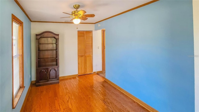 empty room with hardwood / wood-style floors, ornamental molding, and ceiling fan