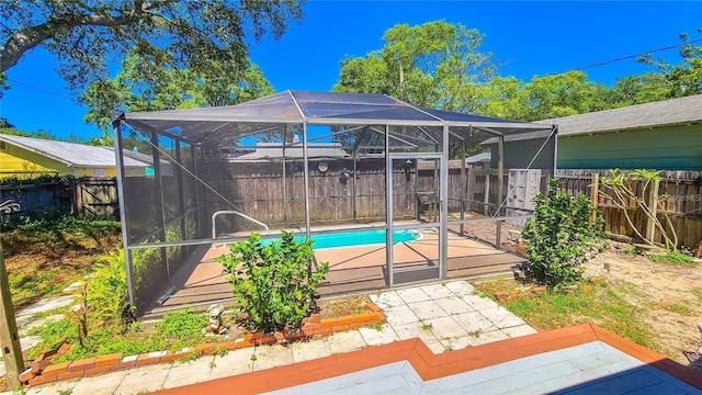 view of swimming pool featuring a wooden deck and a lanai