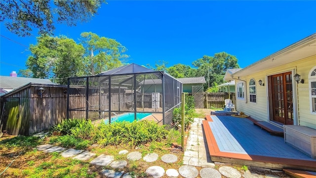 view of pool featuring a wooden deck and a lanai