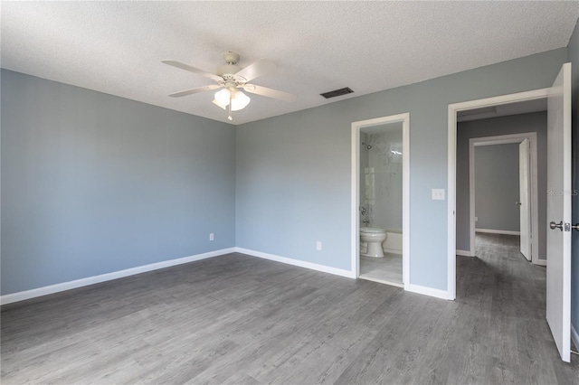 unfurnished bedroom with wood-type flooring, ensuite bathroom, ceiling fan, and a textured ceiling