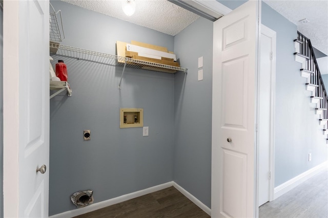 clothes washing area featuring wood-type flooring, hookup for an electric dryer, washer hookup, and a textured ceiling