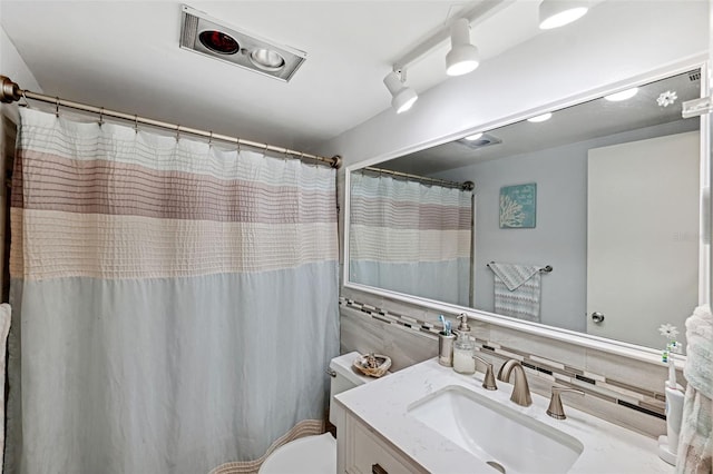 bathroom with vanity, tasteful backsplash, and toilet