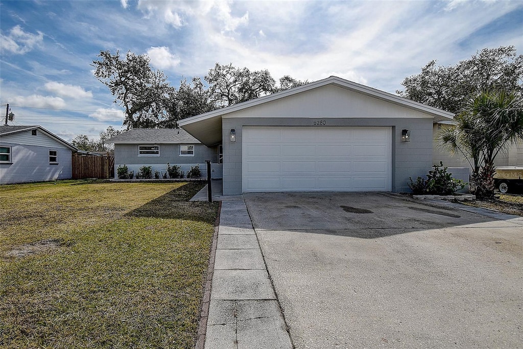 ranch-style house featuring a garage and a front lawn