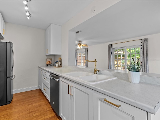 kitchen featuring sink, white cabinets, kitchen peninsula, stainless steel appliances, and light wood-type flooring