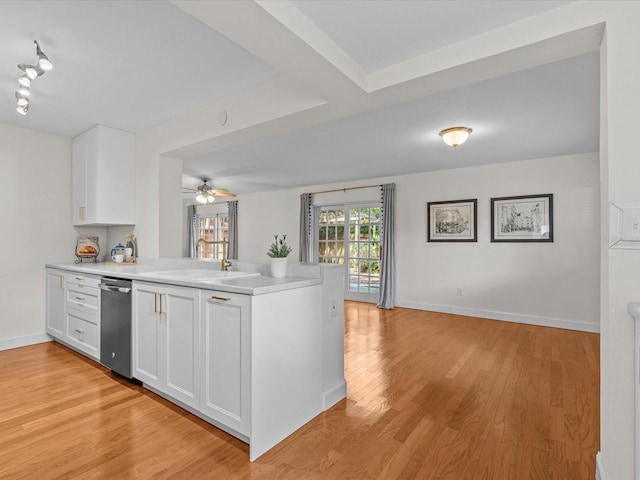 kitchen featuring sink, light hardwood / wood-style flooring, white cabinets, and kitchen peninsula