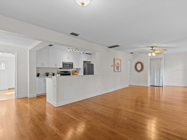 kitchen featuring electric range oven, refrigerator, white cabinetry, ceiling fan, and light wood-type flooring