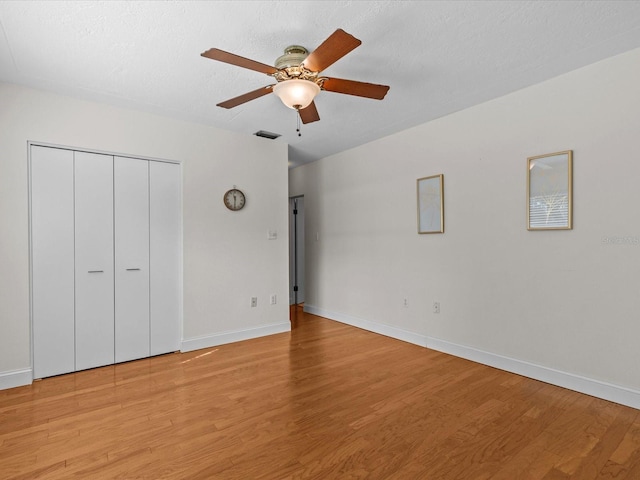 unfurnished bedroom featuring a closet, ceiling fan, a textured ceiling, and light hardwood / wood-style flooring