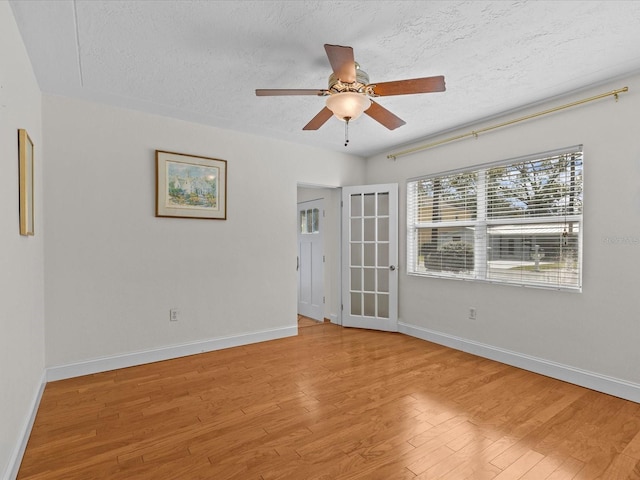 spare room featuring ceiling fan, light hardwood / wood-style flooring, and a textured ceiling