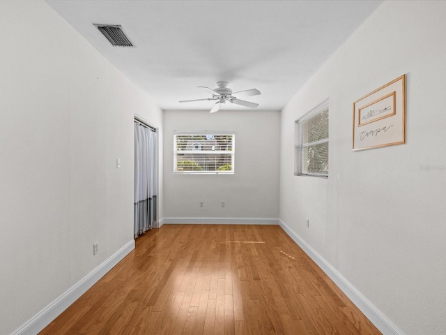 spare room with ceiling fan and light wood-type flooring