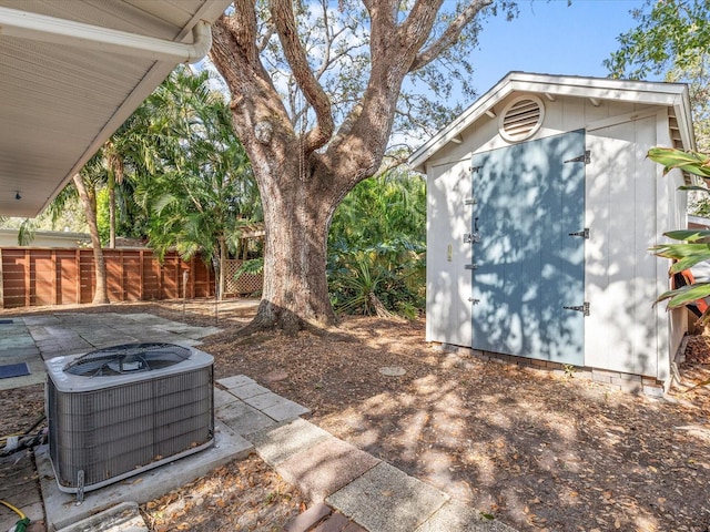 exterior space with central AC unit and a storage shed