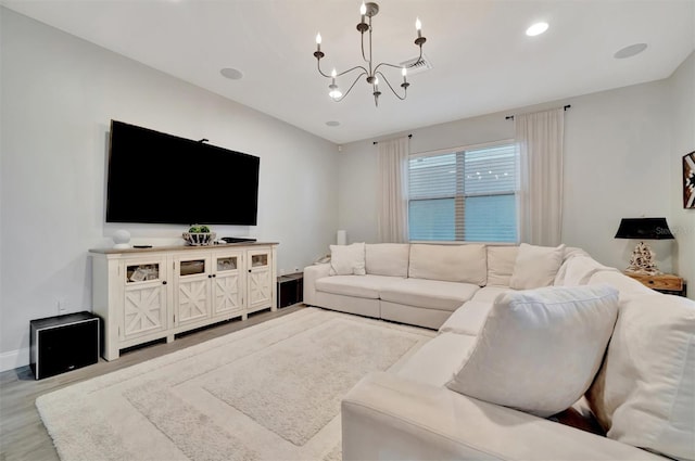 living room featuring a notable chandelier and light wood-type flooring