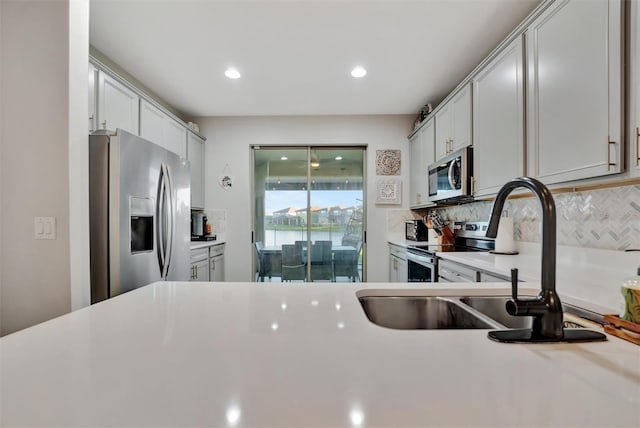 kitchen featuring tasteful backsplash, sink, and appliances with stainless steel finishes