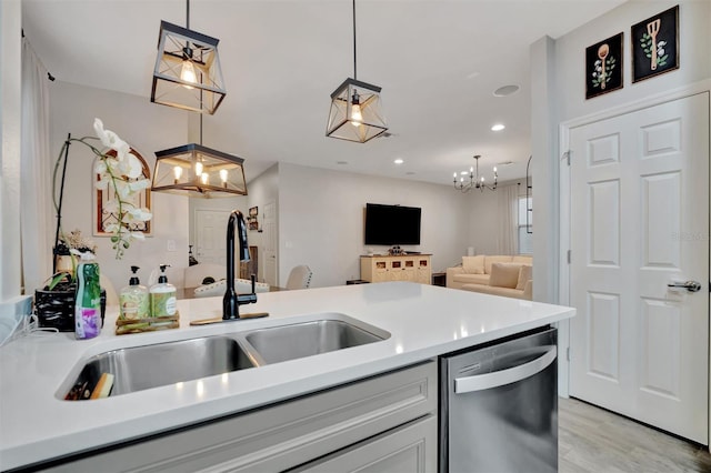 kitchen featuring pendant lighting, dishwasher, sink, and light wood-type flooring