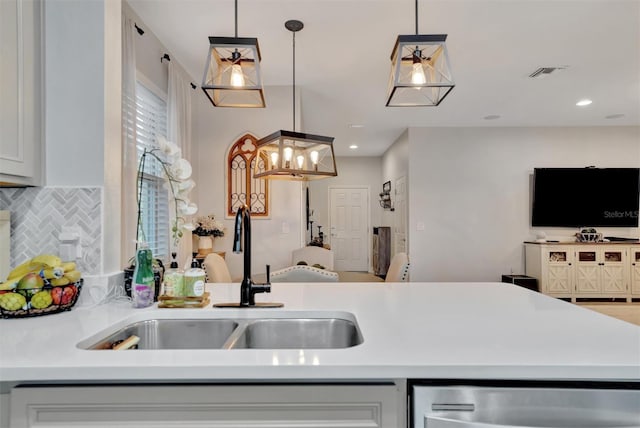 kitchen with dishwasher, sink, pendant lighting, and decorative backsplash