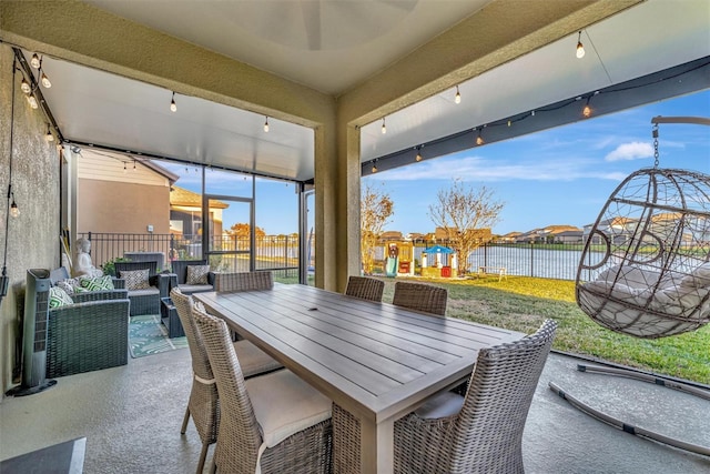 sunroom with a water view and rail lighting