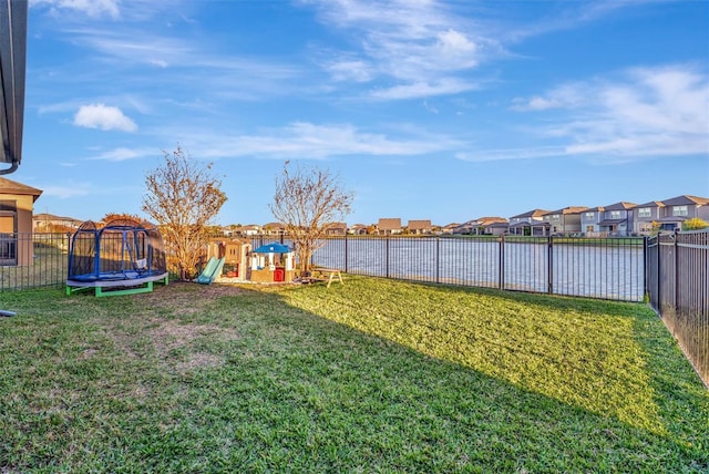 view of yard with a water view and a trampoline