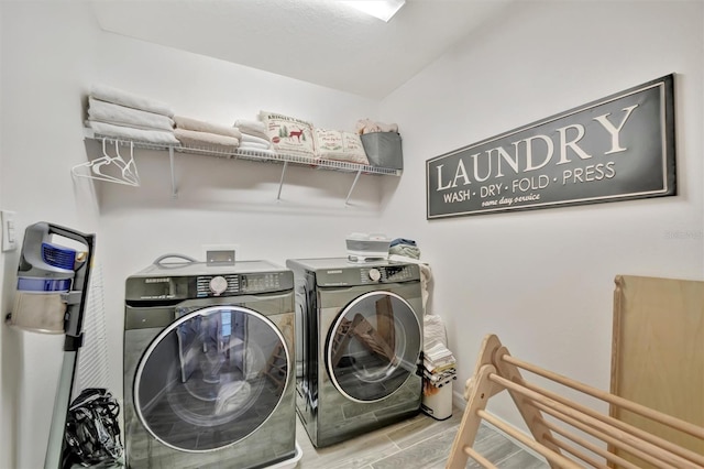 clothes washing area with separate washer and dryer and light wood-type flooring