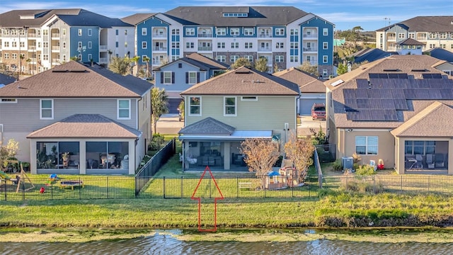 back of house featuring a water view, a yard, central air condition unit, and a sunroom