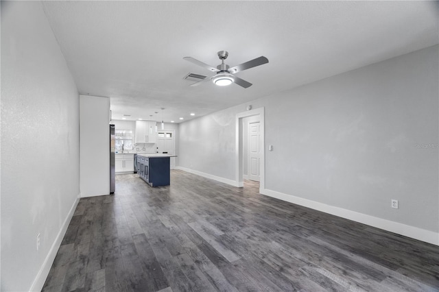 unfurnished living room featuring ceiling fan and dark hardwood / wood-style floors